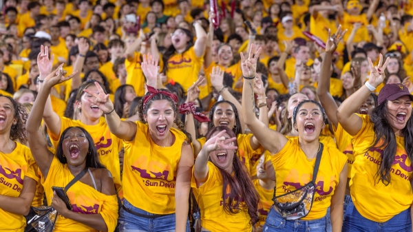 Sea of students wearing gold t-shirts cheer during ASU event