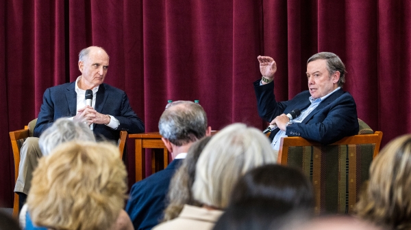 Two people sitting on stage talking to audience