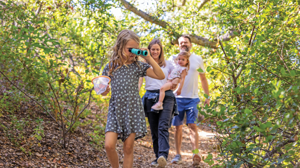 Family of four walking through a trail in the woods