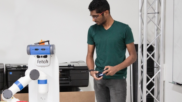 Jayesh Nagpal holds a controller to help train a robot.