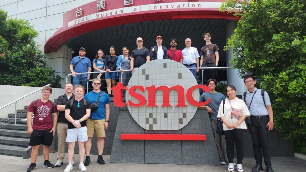 A large group posing around a TSMC sign in Taiwan.