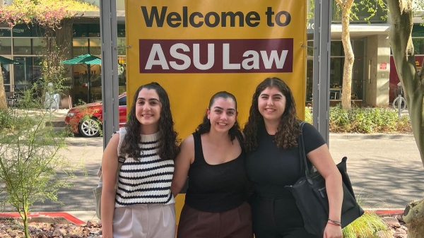 Triplet sisters pose in front of ASU Law sign