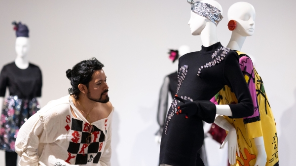 Man inspecting a garment on a manikin.