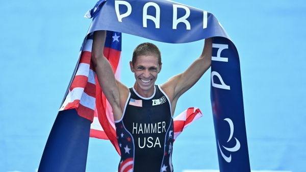 Man holding a banner that reads "Paris" and an American flag.