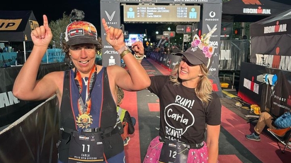 Two women celebrating after crossing Ironman finish line