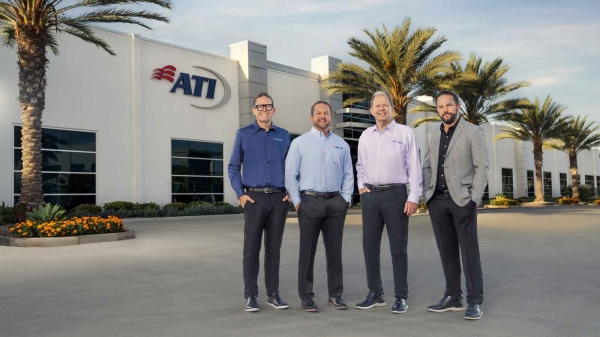 Four men standing in front of the ATI building, surrounded by palm trees.