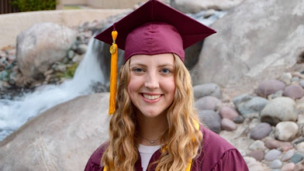 Megan Larsen smiles in her graduation cap and gown