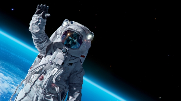 Photo illustration of an astronaut floating in space with a blue planet on the horizon behind him