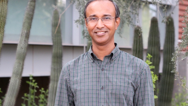 ASU researcher Rahman Masmudur smiling in front of some cacti, wearing glasses and a button down shirt