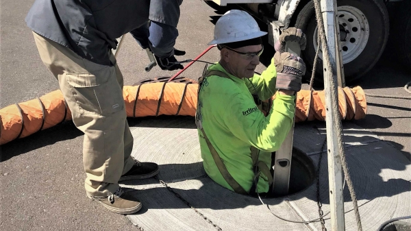 man using ladder to go down manhole