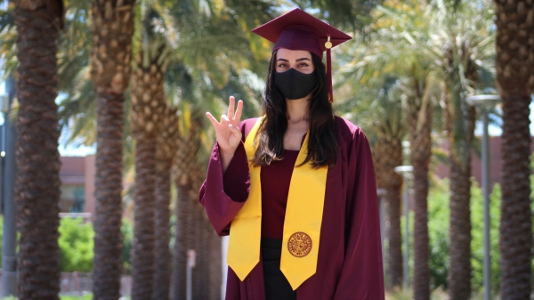 ASU graduate Almasi Sepideh wearing graduationg gown, robe, hat and face mask