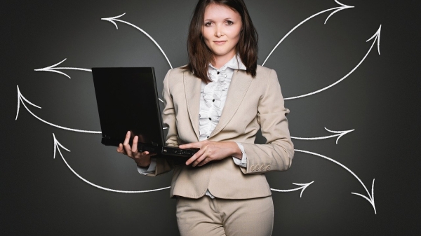 Business woman holding a laptop with arrows drawn behind her in multiple directions.