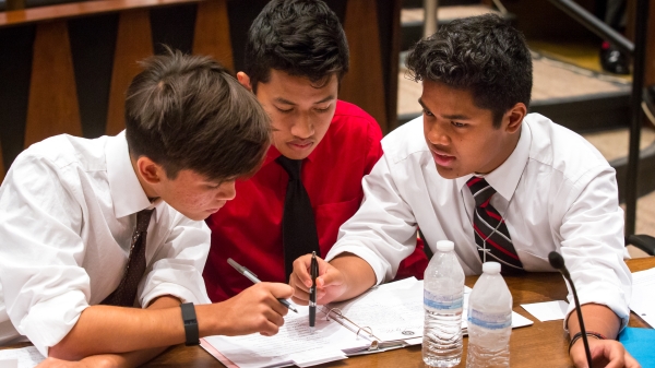 ASU APACE Academy students Marc Flom, 16, left, Dwayne Lanwe, 16, and Randy Oshiro, 15, right, plan strategy in the mock trial 
