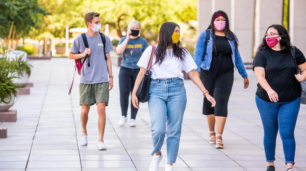 students wearing backpacks and face masks walkin along the mall on ASU's Tempe campus