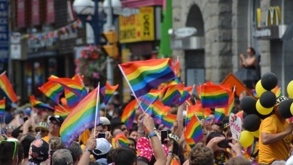 people marching down a street waving rainbow flags