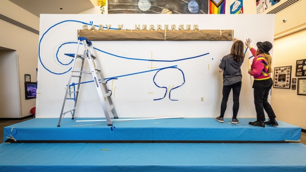 Two students drawing a mural.