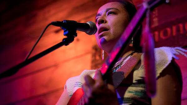 Woman singing and holding guitar