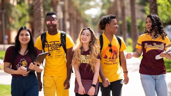 Arizona State University students smiling and walking in a group on campus