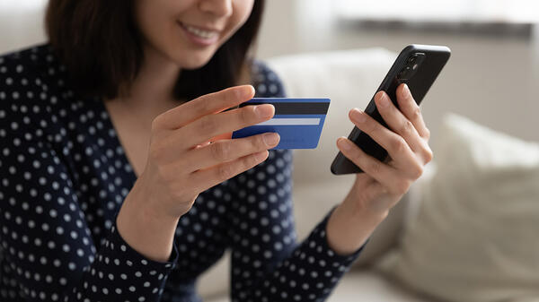 A woman uses a banking app on her smartphone.