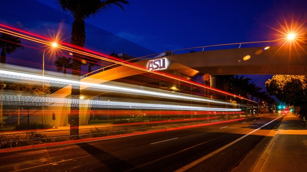 time-lapse photo of car lights going beneath ASU bridge at night