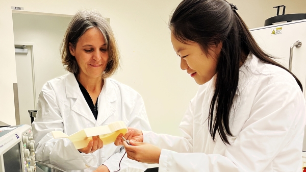 ASU Professor Leila Ladani looks at a sample of a biomedical device with a student in a lab.