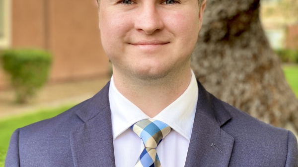 Brinton Carlson poses in front of a tree.