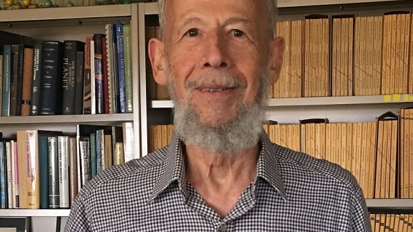 Headshot of Peter Buseck in front of a bookcase.