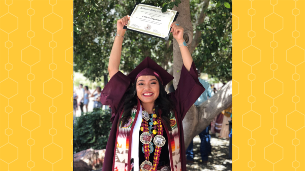 Portrait of ASU transfer student Callie Edgewater wearing a graduation gown, cap and stole and holding up her ASU degree.
