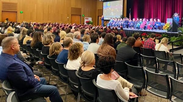 Family and friends seated in the audience watch the convocation ceremony taking place on the stage in front of them