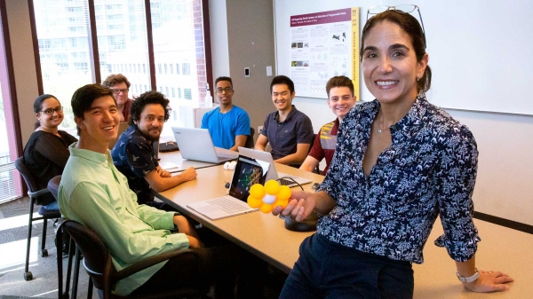 Professor Andréa Richa and her lab group students gathered around a table