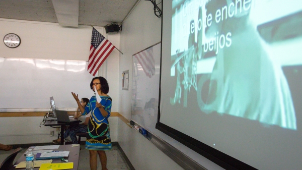 A teacher stands in front of a classroom.