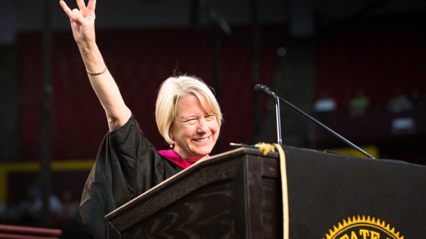 A woman flashes the ASU pitchfork gesture at a commencement speech
