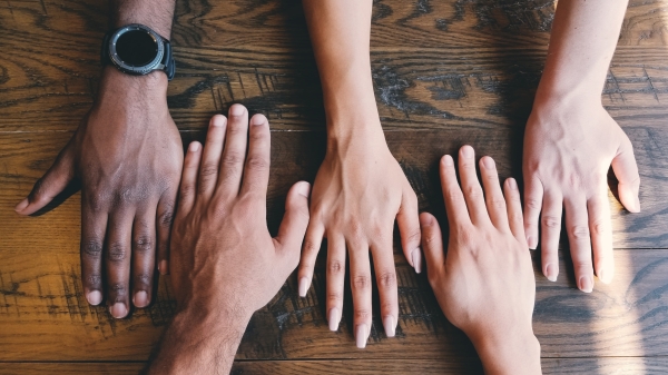 Several peoples hands laid out together on a table.