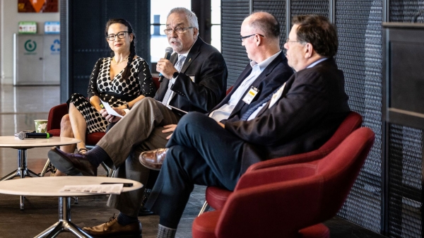 Four people sit on a stage at a panel