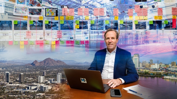 Man sitting at desk with view of Phoenix behind him