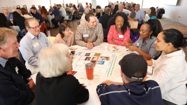 Community members talk around a table