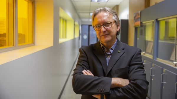 ASU Professor of engineering Michael Kozicki standing with arms folded in a hallway