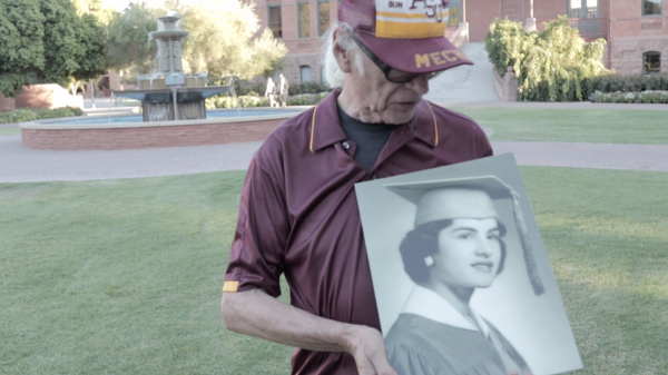 Edward Delci holds a portrait of his late wife, Virginia Pesqueira, in front of Old Main at ASU's Tempe campus