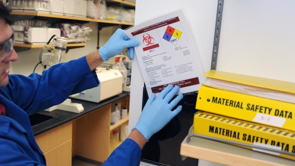 A man posts a lab-safety warning in an ASU lab. 