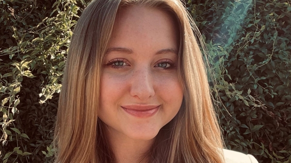 headshot of elizabeth quigley smiling with foliage behind her