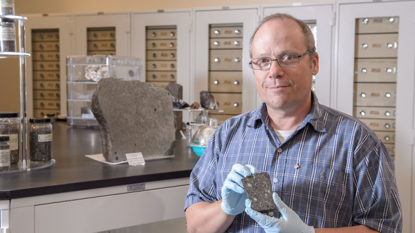 Professor Laurence Garvie holds meteorite.