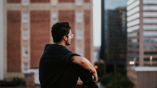 man sitting on the ledge of a building