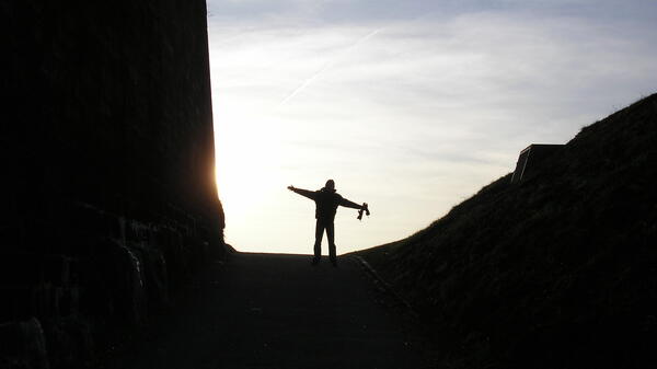 person with outstretched hands looking at sky