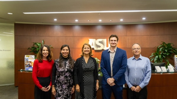 Members of inaugural cohort of Global Partner Affiliated Faculty pose side by side with ASU Vice President of Global Academic initiatives and President of Cintana Education in front of ASU sign