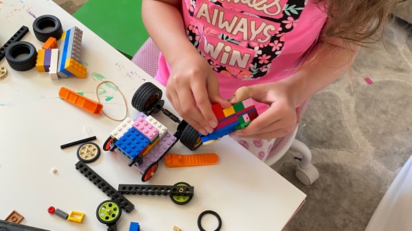 a young girl building with LEGO