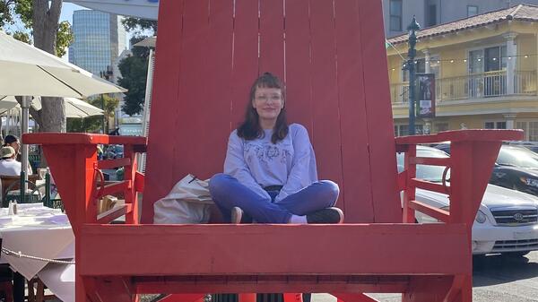 ASU student Genevieve Hook sitting in an oversized, red chair.