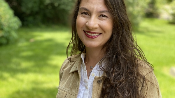 Portrait of ASU Professor Ayşe Çiftçi outside with a natural backdrop of green grass and leafy trees.