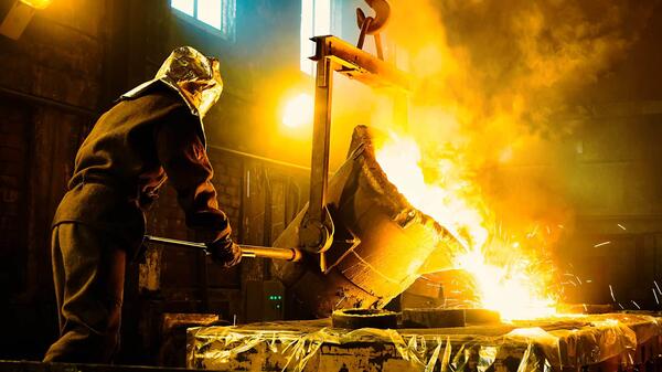 Person using machinery to melt metal.