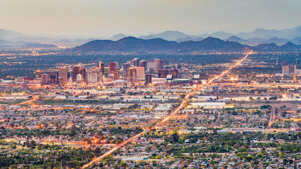 Skyline of Phoenix shown at twilight with building and street lights coming on