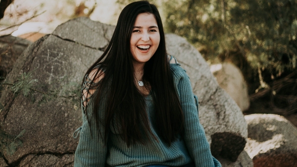 Graduating ASU student Jasmin Figueroa sits on a rock. / Courtesy photo